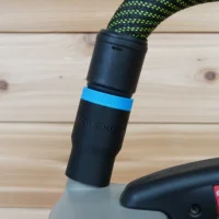 Black hose adapter with blue band attached to Porter Cable belt sander dust port, with green and black braided hose connected above