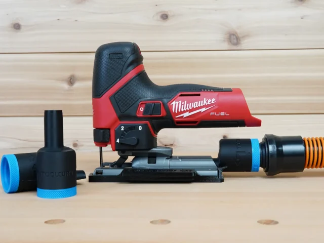 Black 1-1/4 inch hose adapter with blue collar installed on a Milwaukee M12 Fuel jig saw, second adapter alongside