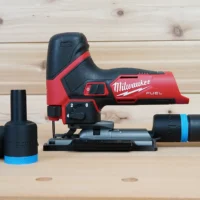 Black ToolCurve hose adapters with blue bands beside a Milwaukee M12 Fuel jig saw, one joined to a vacuum hose