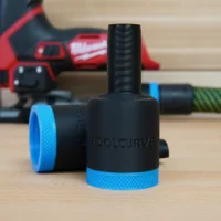 Black hose adapter with blue grip rings attached to Milwaukee M12 Fuel jig saw dust port, shown on workbench with jig saw in background