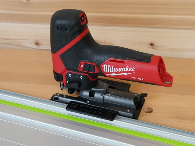 Milwaukee M12 Fuel jig saw mounted on an aluminum guide rail with a black plastic adapter base