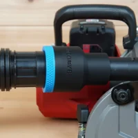 Black ToolCurve 1-7/8 inch hose adapter with blue grip ring joining a vacuum hose to a Milwaukee M18 rear handle circular saw dust port