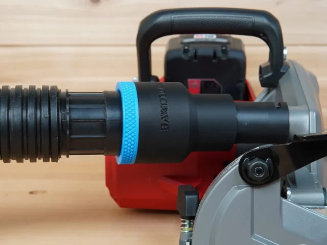 Black ToolCurve 1-7/8 inch hose adapter with blue grip ring joining a vacuum hose to a Milwaukee M18 rear handle circular saw dust port