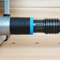 Black ToolCurve 1-7/8 inch hose adapter with blue band linking a ribbed vacuum hose to a FLEX table saw dust port