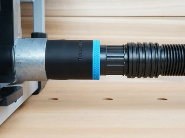 Black ToolCurve 1-7/8 inch hose adapter with blue band linking a ribbed vacuum hose to a FLEX table saw dust port