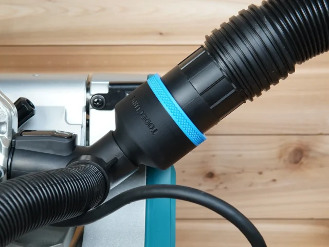 Black ToolCurve 2-1/2 inch hose adapter with blue ring installed on a Makita miter saw dust port