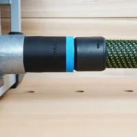 Black ToolCurve 36mm hose adapter with blue ring linking a green-striped hose to a FLEX table saw dust port