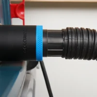 Black ToolCurve 1-7/8 in hose adapter with blue band joining a vacuum hose to a Bosch table saw dust port