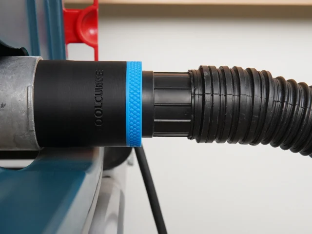 Black ToolCurve 1-7/8 in hose adapter with blue band joining a vacuum hose to a Bosch table saw dust port