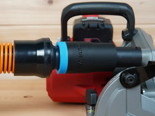 Black ToolCurve 1-1/4in hose adapter with blue grip ring joining an orange hose to a Milwaukee M18 rear handle circular saw dust port