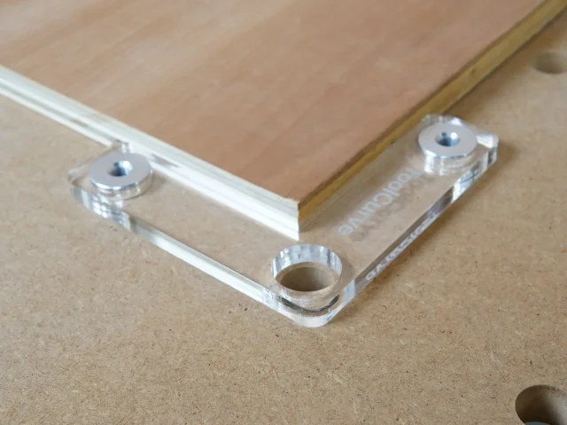 Clear acrylic fence stops with aluminum bench dogs installed in 20mm workbench holes, showing corner and straight stop configurations