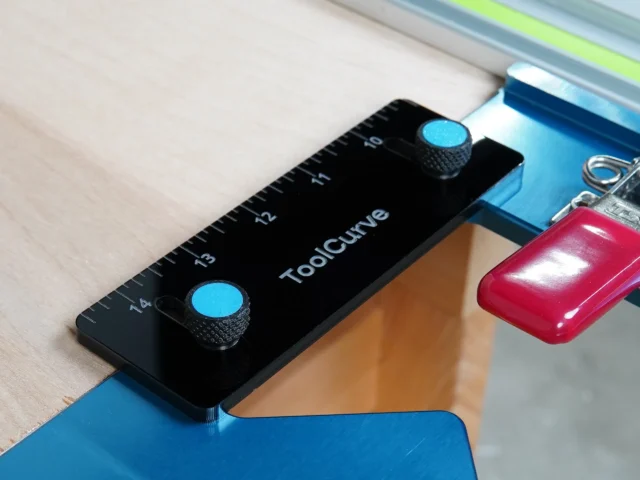 Black acrylic support tab with two blue thumb screws, mounted on blue TSO guide rail square with ruler markings
