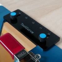Black TSO guide rail square support tab with blue thumb screws, mounted on blue guide rail square above red DeWALT track saw connector