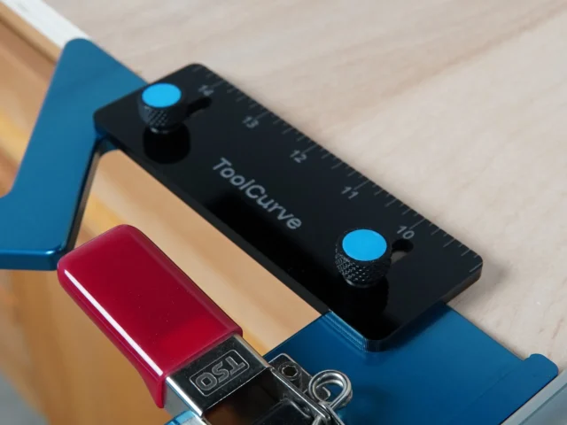 Black TSO guide rail square support tab with blue thumb screws, mounted on blue guide rail square above red DeWALT track saw connector