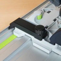 Black anti-tip guide installed on Festool TS 55 track saw rail, showing knurled adjustment knob and mounting bracket