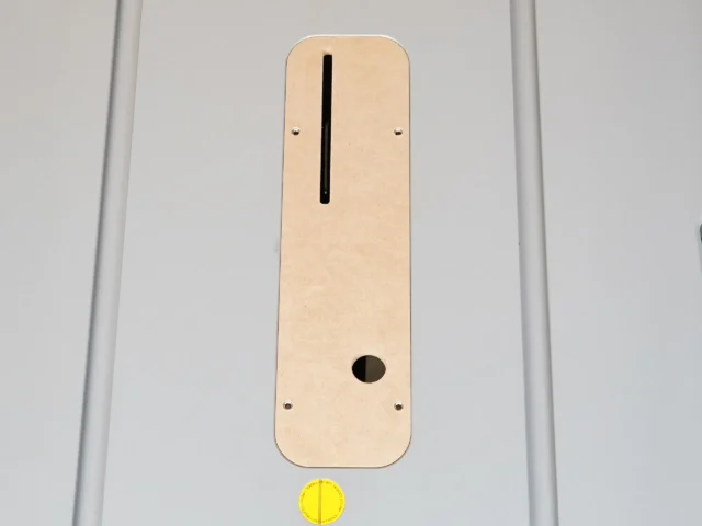 Tan MDF zero clearance insert for Bosch 4100 table saw, shown flat with vertical slot and round opening, mounted with stainless screws