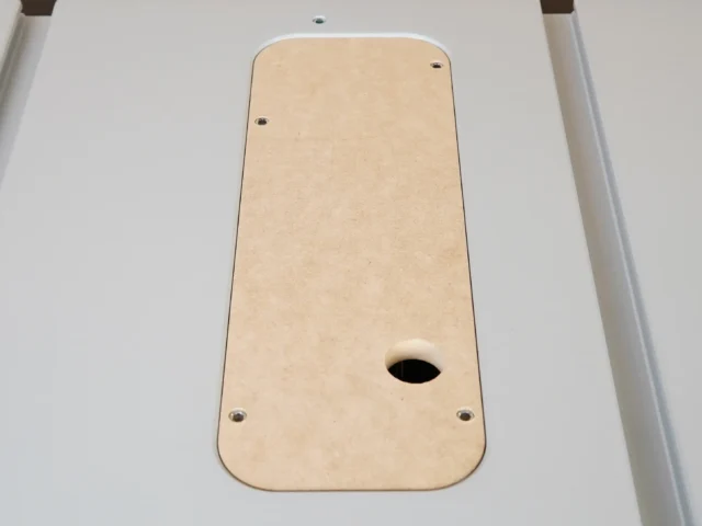 Tan MDF zero clearance insert for FLEX 8-1/4" table saw, shown from above with oval blade opening and four mounting holes