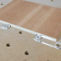 Clear acrylic fence stops with aluminum 20mm bench dogs seated in workbench holes