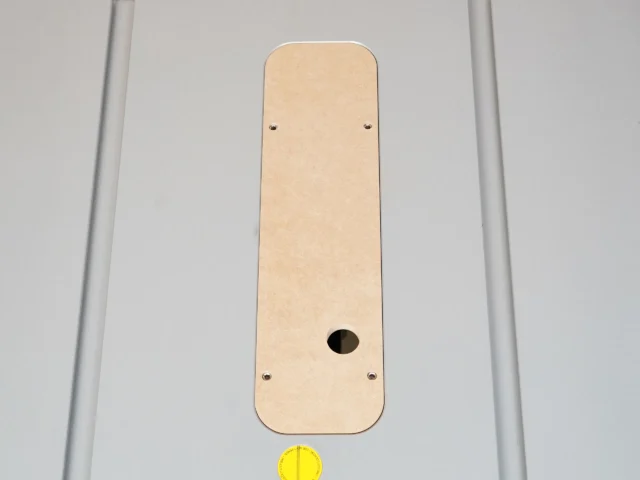Cream-colored MDF zero clearance insert for Bosch 4100 table saw, rectangular with rounded corners, oval blade opening near bottom, and four adjustment screw holes
