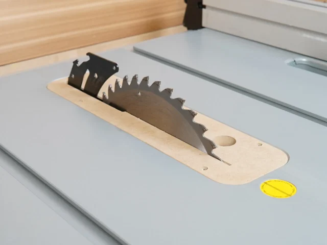 Wood and black plastic zero clearance insert for Bosch 4100 table saw, mounted on saw table with saw blade visible