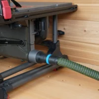 Hose adapter with blue band attached to SKIL table saw's rear dust port, connected to green and black hose