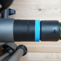 Black ToolCurve 36mm hose adapter with blue ring joining a dust extractor hose to a SKIL table saw port