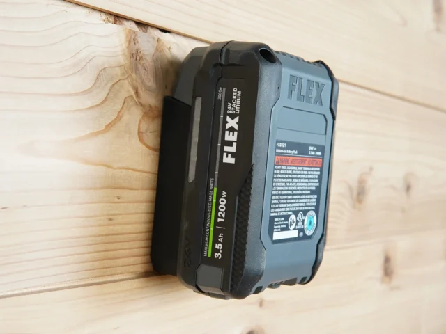 ToolCurve battery mount holding a FLEX 24v lithium battery mounted horizontally on wooden wall
