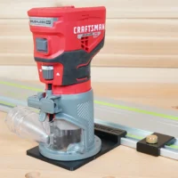 Craftsman 20v router mounted on a black ToolCurve guide rail adapter base riding a track saw rail