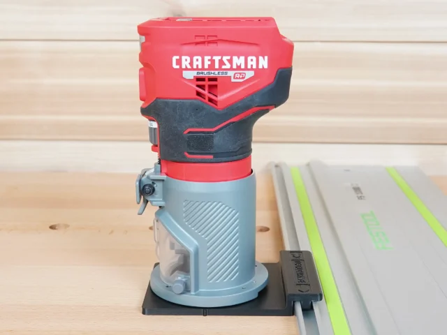 Craftsman 20v brushless router mounted on black guide rail adapter, positioned on Festool track saw rail on wooden workbench