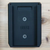 Black plastic FLEX battery mount with recessed slot and two Phillips screws, shown front view