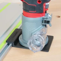 Craftsman 20v router mounted on guide rail adapter, attached to aluminum track with lime stripe, dust collection port visible below router base