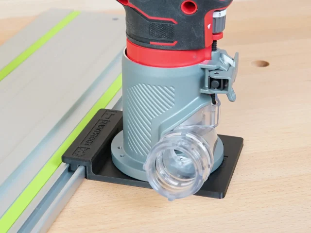 Craftsman 20v router mounted on guide rail adapter, attached to aluminum track with lime stripe, dust collection port visible below router base