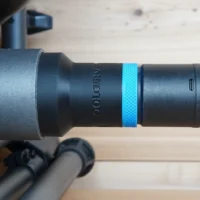 Black hose adapter attached to SKIL table saw dust port, with blue identification band and braided hose connected