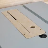 Zero clearance insert for Bosch GTS18 table saw, showing light wood insert with central slot, round hole, and mounting holes installed on gray saw table