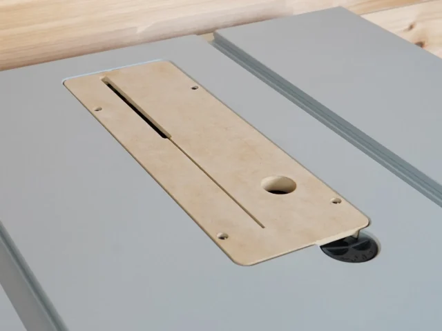 Zero clearance insert for Bosch GTS18 table saw, showing light wood insert with central slot, round hole, and mounting holes installed on gray saw table