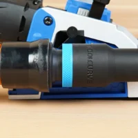 Black 1-1/4 inch hose adapter with blue grip ring joining an orange vacuum hose to a Kreg Rebel joiner port