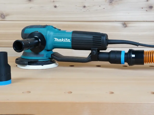 Black 1-1/4 inch hose adapter with blue band installed on a Makita random orbit sander, second adapter alongside