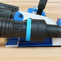 Black 1-7/8 inch hose adapter with blue grip ring joining a vacuum hose to a blue Kreg Rebel joiner port
