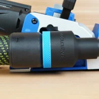 Black 36mm ToolCurve hose adapter with blue grip ring joining a green hose to a blue Kreg Rebel joiner