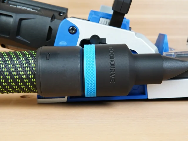 Black 36mm ToolCurve hose adapter with blue grip ring joining a green hose to a blue Kreg Rebel joiner