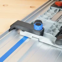Anti-Tip Guide mounted on Kreg ACS track saw with blue knob tightened, installed on aluminum rail with blue tape