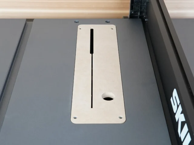 White MDF zero clearance insert mounted in SKIL 10" table saw, showing centered slot and mounting holes