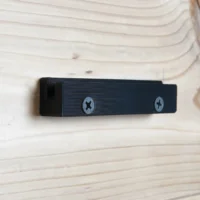 Black wall mount holder with screw holes for attaching a track saw guide rail square to shop wall or cabinet