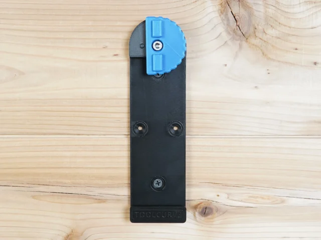 Black plastic wall mount with blue lever clamp for Kreg Accu-Cut track saw rail, shown flat with three screw holes visible