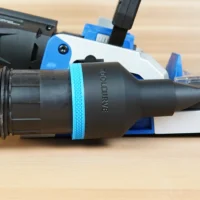 Black ToolCurve 2-1/2 inch hose adapter with blue band joining a vacuum hose to a blue Kreg Rebel joiner