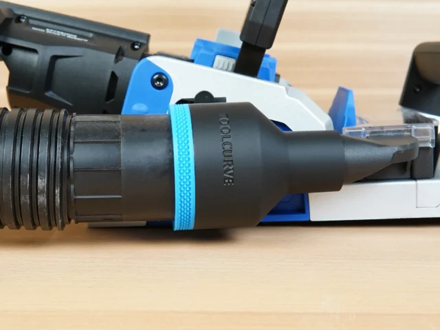 Black ToolCurve 2-1/2 inch hose adapter with blue band joining a vacuum hose to a blue Kreg Rebel joiner