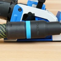 Black hose adapter with cyan band attached to Kreg Rebel pocket hole joiner dust port, connected to green and yellow braided hose