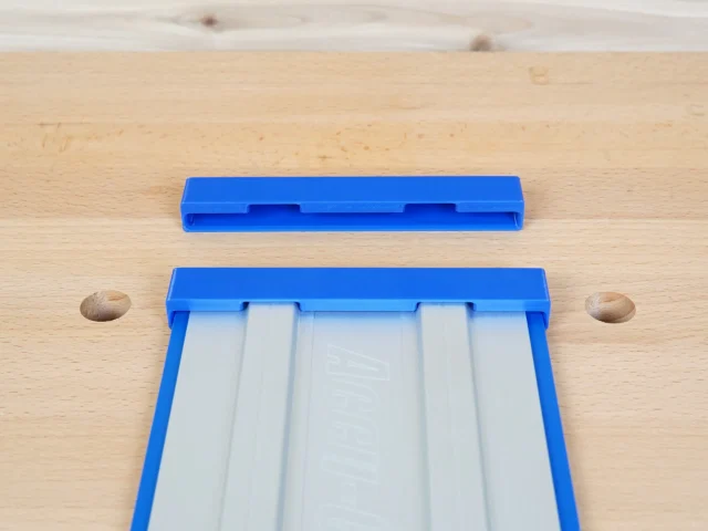 Two blue PETG protective caps for Kreg Accu-Cut guide rails, one installed on a rail showing interior channels, one separate above