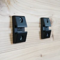 Two black MFT-compatible wall mounts attached to light wood, each with mounting holes and T-track slots labeled MFT