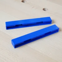 Two blue PETG protective caps with hollow channels, designed to slide onto the ends of Kreg Accu-Cut track saw rails